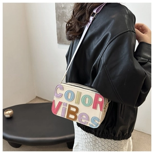 Dettaglio della borsa a tracolla panna con applicazioni di lettere colorate in rilievo 3D