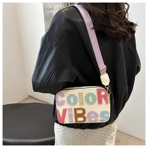 Dettaglio borsa a tracolla beige con scritta COLOR VIBES colorata in rilievo da donna
