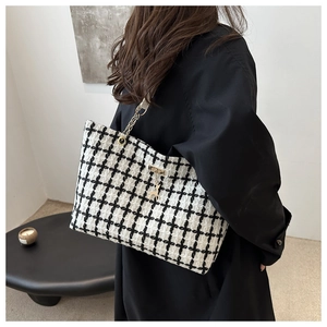 Détail du sac cabas en tweed à carreaux avec chaîne dorée et pendentif cerf
