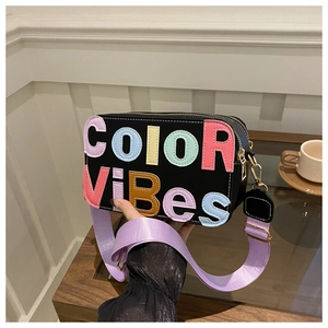 Dettaglio borsa a tracolla nera con scritta Color Vibes a rilievo e tracolla lilla