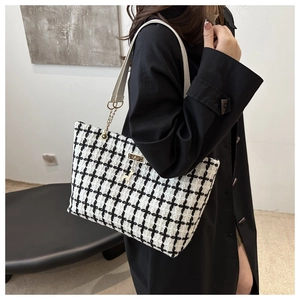 Détail du sac cabas en tweed à carreaux avec breloque cheval dorée et bandoulière