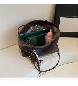Interior storage view of dark brown tote bag showing capacity for tablet and gadgets