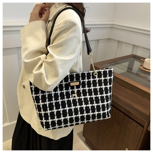 Détail du sac cabas à carreaux noir et blanc avec breloque cerf dorée et bandoulière