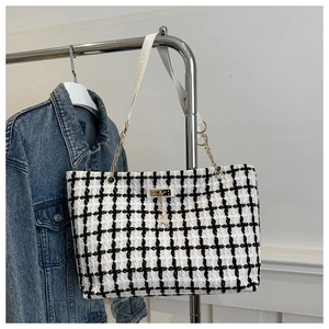 Détail du sac cabas en tweed à carreaux avec chaîne dorée et pendentif cerf