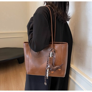 Brown leather tote bag featuring cute dachshund and chocolate pendants for a stylish look