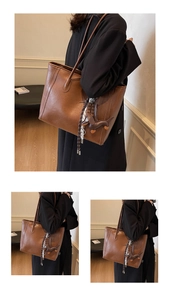 Detail of brown tote bag with leather tassel and dachshund charm over black coat
