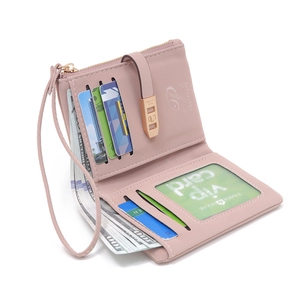 Short pink PU leather wallet for women with card slots and wristlet strap on white background
