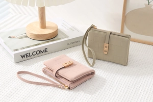 Short PU leather wallets with wristlet and gold buckle detail on a textured surface