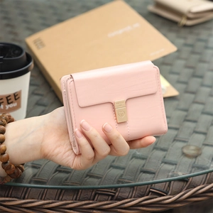 Gros plan du portefeuille en cuir PU rose clair avec un fermoir en métal doré en forme de cœur