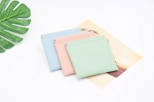 Detail of three PU leather spring-closure storage pouches in blue, pink, and mint green