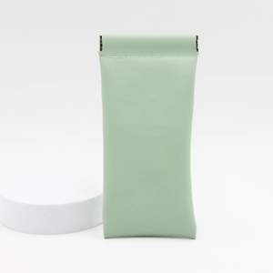 Detail view of mint green leather sunglasses pouch with self-closing metal spring clip