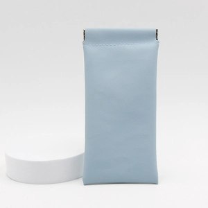 Close-up of light blue leather glasses pouch featuring an automatic spring clip closure