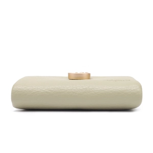 Detailed bottom view showing lychee pattern PU leather and golden clasp on beige wallet