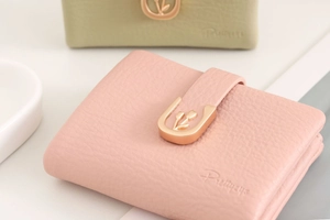 Detailed close-up of pink and green PU leather wallets with U-shaped gold hardware details