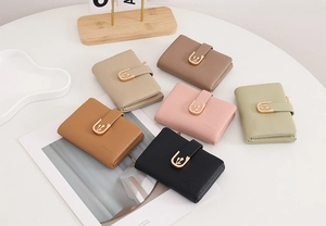 Flat lay of women's short bifold wallets in multiple colors with gold flower buckles