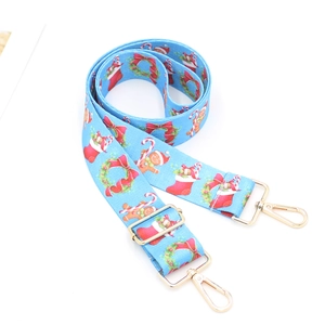 Detail of Christmas themed blue bag strap with festive patterns and gold metal buckles