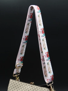 Detail of Christmas-themed pink wide shoulder strap with golden metal swivel hooks