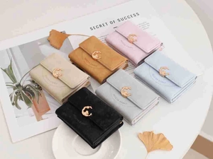Flat lay of vintage tri-fold wallets in six colors with matte gold hardware buckle