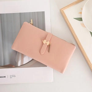 Detail of light pink PU leather wallet featuring a gold puzzle piece charm and zipper