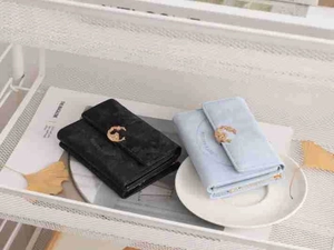 Detail of vintage matte wallets in black and blue with golden animal hardware buckles