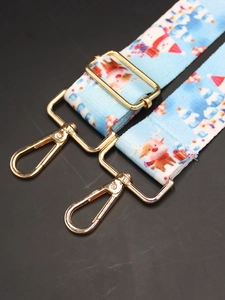 Close-up of sky blue Christmas bag strap with gold lobster clasps and reindeer patterns
