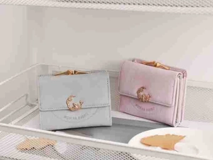Close-up of vintage tri-fold wallets in light grey and lavender with metal buckle detail