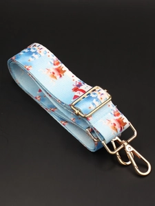Close-up of light blue Christmas themed bag strap with golden metal lobster clasps