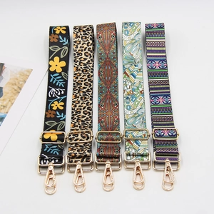 Five assorted printed bag straps with gold hardware displayed on a white background