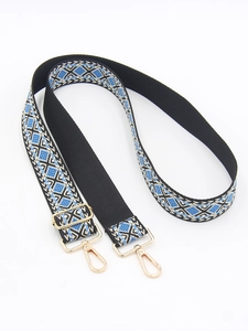Dettaglio della tracolla jacquard etnica con motivi blu e fibbie in metallo dorato lucido
