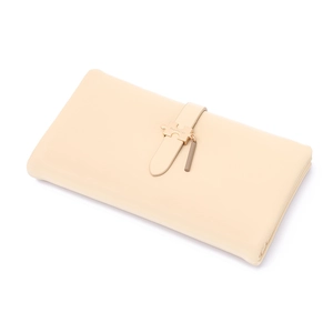 Detailed macro of beige PU leather long wallet with golden puzzle-shaped metal buckle