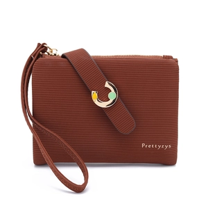 Detailed macro view of brown textured leather wallet with gold C-buckle and zipper