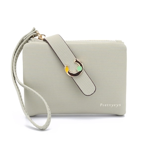 Close-up of light green textured leather wallet with horseshoe metal buckle and wristlet