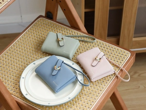 Detailed view of textured leather women wallets with U-shaped metal buckle and wrist strap