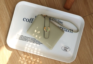 Top view of a sage green textured short wallet with a horseshoe buckle and wrist strap