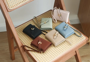 Detailed collection of multiple colored ladies' short wallets arranged on a wooden chair