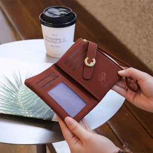 Women's tri-fold brick red leather wallet with card slots and a wrist strap
