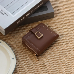 Detail of brown PU leather wallet featuring white stitching and secure snap closure