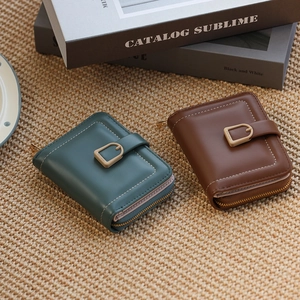 Detail of vintage PU leather wallets in dark teal and warm brown with D-ring hardware