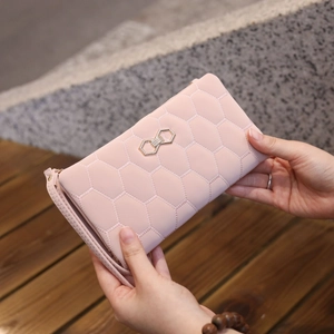Close-up of pink quilted long wallet with golden hexagonal buckle and zip detail
