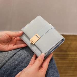 Cartera corta de cuero azul claro de tres pliegues con elegante hebilla dorada y logo
