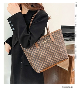 Détail du sac cabas à monogramme quadrillé avec garniture en cuir sur un modèle au bureau
