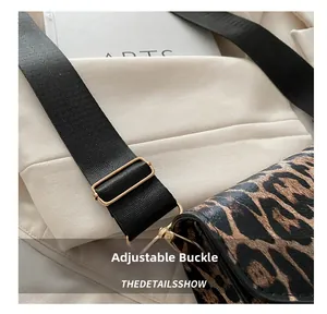 Détail du sac léopard avec boucle métallique dorée et bandoulière en tissu noir
