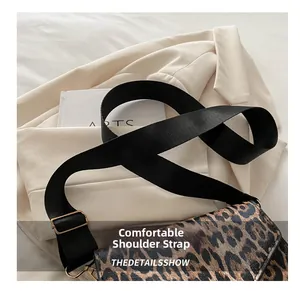 Détail du sac léopard avec bandoulière large noire réglable et boucle dorée chic