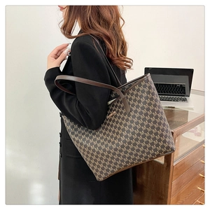 Détail du sac cabas marron foncé avec motif M et poignées en cuir pour femme