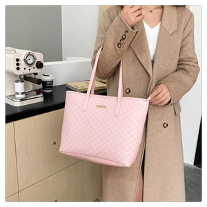 Gros plan sur le sac fourre-tout rose avec motif M et plaque métallique dorée chic