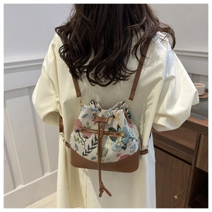 Detailed back view of floral tapestry drawstring bucket bag with adjustable straps