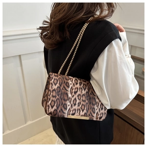 Détail d'un sac léopard avec bandoulière chaîne dorée sur un décor de style vintage