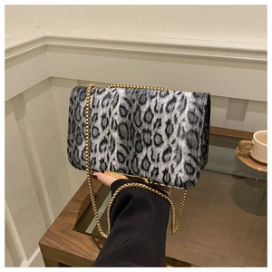 Détail du sac à bandoulière léopard avec bandoulière chaîne dorée et finitions métal