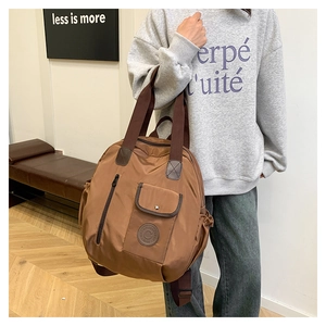 Brown nylon multi-pocket backpack worn by a model in a minimalist indoor setting