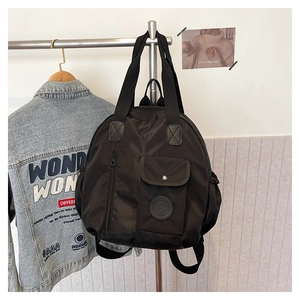 Detail of black waterproof nylon backpack with front flap pocket and sturdy carry handle